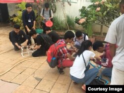 សិស្ស​ដែល​ចូលរួម​ប្រកួត​រ៉ូបូត​ក្នុង​ទឹក​ ធ្វើ​ការ​តេស្ត​សាកល្បង​រ៉ូបូត​ខ្លួន​ក្នុង​អាង​ហែល​ទឹក​ នៅ​ពហុកីឡាដ្ឋាន​ជាតិ​អូឡាំពិក​ កាល​ពី​ខែ​មករា​ ឆ្នាំ​២០១៨​។ (រូប​ពី​ STEM Cambodia)