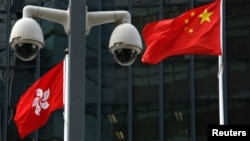 資料照：在香港總部大樓外監控攝像頭後的中國國旗和香港特區旗幟。