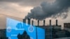 FILE - Pedestrians and an electronic screen displaying COVID-19 prevention advice is reflected in a glass wall as smog billows from a factory in Moscow, Dec. 3, 2020.
