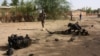 (Photo d’archives) Des soldats nigériens marchent près des débris après une attaque-suicide à l'intérieur d'une caserne militaire, à Agadez, dans le nord du Niger, le jeudi 23 mai 2013.