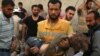 A medic carries the body of a child after airstrikes in the rebel-held Karam Houmid neighborhood in Aleppo, Syria, Oct. 4, 2016.