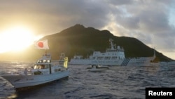 中國海監船51號（中）在東中國海域的釣魚島，日本稱作尖閣列島的有爭議海島旁航行，日本海岸警衛隊的船隻在旁（右），前船為日本漁船。（2013年7月1日）