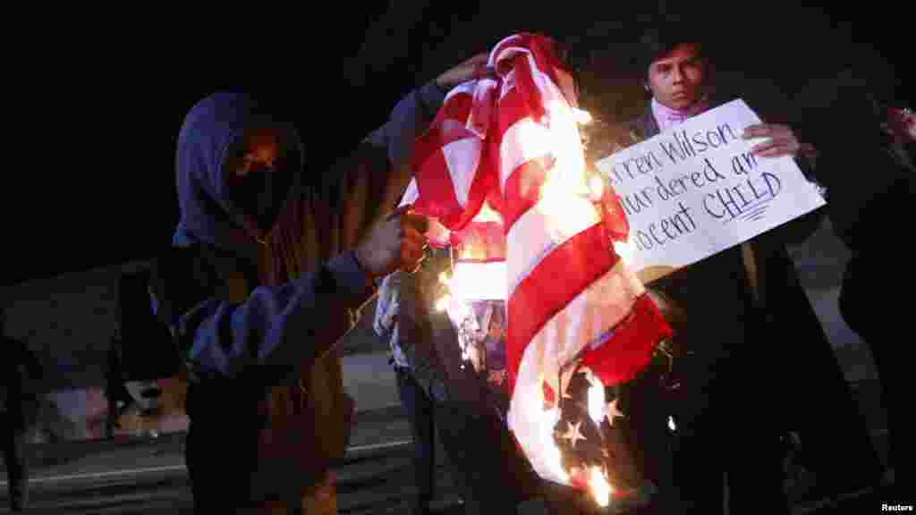 Un manifestant brûle un drapeau américain sur l'autoroute 580 lors d'une manifestation après la grande décision du jury dans la fusillade de Michael Brown, à Oakland, en Californie, le 24 novembre 2014.