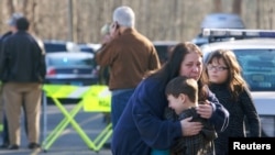 Un enfant consolé près de l'école primaire de Newtown