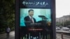 A man and vehicles pass by an electronic display panel advertising a video footage of Chinese President Xi Jinping on a street in Beijing, May 24, 2018. China and Japan have both condemned the Trump administration's decision to launch an investigation into whether tariffs are needed on imports of vehicles and automotive parts into the United States.