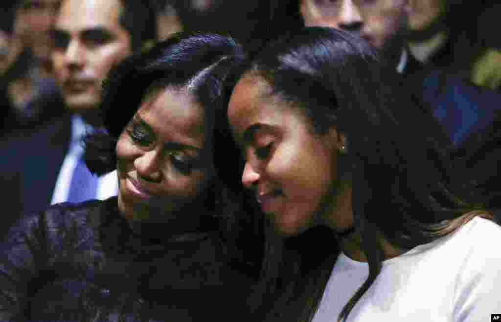 ស្រ្តីទី១ អ្នកស្រី Michelle Obama និងកូនស្រីនាង Malia ផ្អែកគ្នាទៅវិញទៅមកខណដែលពួកគេស្តាប់ ប្រធានាធិបតីបារ៉ាក់ អូបាម៉ា កំពុងធ្វើសេចក្តីថ្លែងចុងក្រោយនៅសណ្ឋាគារ McCormick Place ទីក្រុង Chicago កាលពីថ្ងៃទី១០ មករា ២០១៧។