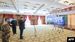 戴著口罩的中國國家主席習近平視察火神山醫院時通過視頻向新冠病毒感染者和醫護人員招手。 （2020年3月10日）