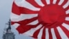 FILE - In this Oct. 14, 2012, photo, Japan Maritime Self-Defense Force escort ship Kurama, left, navigates behind destroyer Yudachi, with a rising sun flag, during a fleet review in water off Sagami Bay, south of Tokyo. 