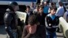 FILE - Police block a road out of Simferopol, Crimea, May 18, 2015, while young Tatars walk away during a march to mark the 71st anniversary of Soviet dictator Stalin's 1944 mass deportation of Crimean Tatars. 