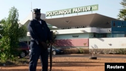 Un police se tient devant une clinique à Bamako, le 12 novembre 2014.