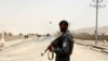 FILE - An Afghan policeman stands guard near the site of a suicide bomb attack on a NATO convoy in Kandahar, south of Kabul, Afghanistan, Aug. 2, 2017.