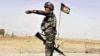 FILE - Afghan National Army soldier directs a vehicle to stop at a checkpoint on the way to Zhari district, where the Maiwand army base is located, in Kandahar, Afghanistan.