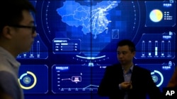 在北京舉行的全球移動互聯網大會上，參觀者站在一個顯示中國地圖的電子數據顯示器前(2018年4月26日)
