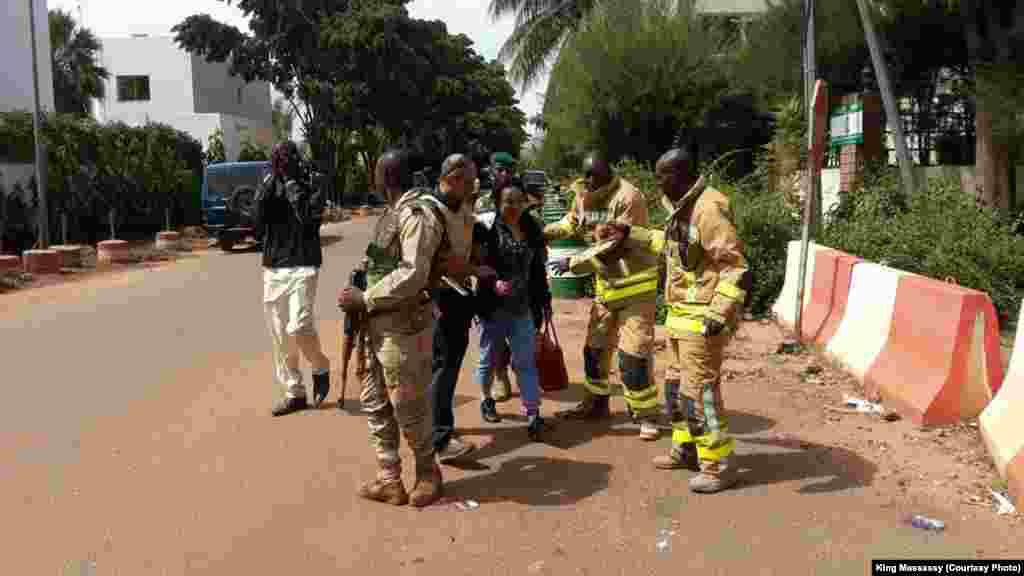 Les éléments de force de sécurité et les secours encadrent des personnes évacuées du lieu de l'attaque de Bamako, Mali, 20 novembre 2015. (crédit : King Massasy)