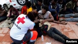 Un membre de la Croix rouge espagnole assistant des migrants après le naufrage de leur embarcation entre le Maroc et l'Espagne, 31 octobre 2016.