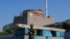 FILE - A Russian service member stands guard at a checkpoint near the Zaporizhzhia Nuclear Power Plant before the arrival of the International Atomic Energy Agency (IAEA) expert mission in the Zaporizhzhia region, Russian-controlled Ukraine, June 15, 2023.