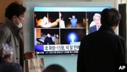 People watch a TV screen showing a local news program reporting about North Korea's missile launch, at the Seoul Railway Station in Seoul, South Korea, Nov. 30, 2017.