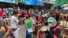 People stand in lines to get COVID-19 tests in Samut Sakhon, South of Bangkok, Thailand, Sunday, Dec. 20, 2020. Thailand reported more than 500 new coronavirus cases on Saturday. (AP Photo/Jerry Harmer)