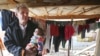 FILE - U.N. special adviser Jan Egeland holds a Syrian baby during his visit to a refugee camp in the town of Marej in the Bekaa valley, east Lebanon, Feb. 25, 2015. 