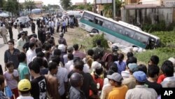 FILE: Crowds of people watch a bus collided with a motorcycle on the outskirts of Phnom Penh, Cambodia, Sept. 24, 2009. 