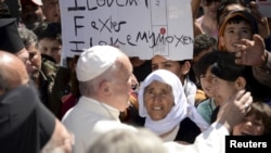 Le pape Francis accueillant des migrants et des réfugiés dans le camp de Moria près du port de Mytilene, sur l'île grecque de Lesbos, le 16 avril 2016.