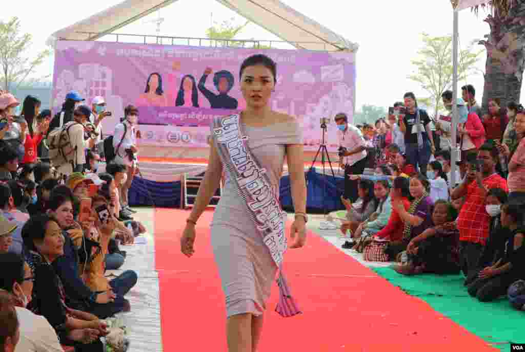 A women performs fashion show with slogans to promote respect for women's rights as groups of citizens, workers, and civil society representatives celebrate the 109th International Women Rights Day at Freedom Park in March 8, 2020. (Kann Vicheika/VOA Khmer)