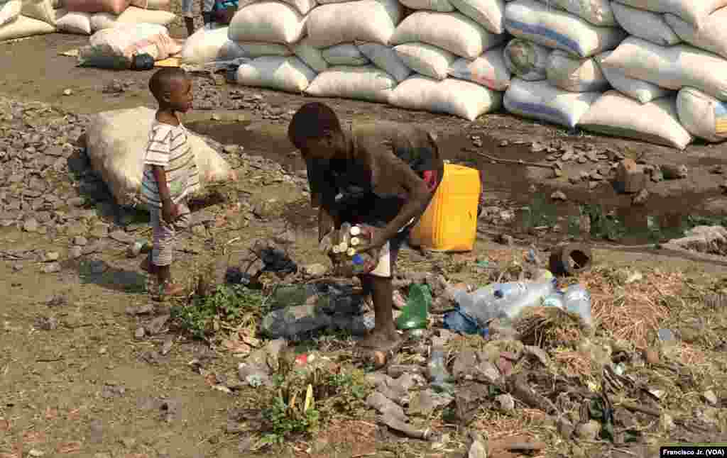 Meninos apanham garrafas de plástico vazias na estação de Caminhos de Ferro de Moçambique em Moatize