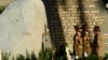 FILE - Cuba's President Raul Castro stands before the tomb of his brother, Cuba's late leader Fidel Castro, on the one year anniversary that Fidel was buried, in Santiago, Cuba, Dec. 4, 2017. 
