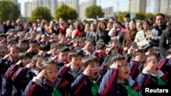 2018年2月23日，中國上海一所小學新學期第一天舉行的升旗儀式上，學生致敬。