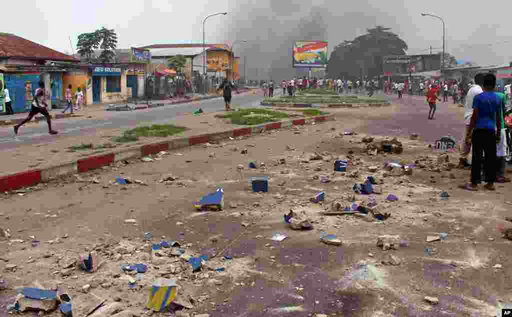 Des peirres sont visibles dans une rue principale pendant que des manifestants brûlent des pneus lors d'une manifestation contre une nouvelle loi qui pourrait retarder l'élection prévue pour 2016 àKinshasa, République démocratique du Congo, le lundi 19 janvier 2015,