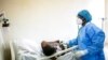 Un médecin utilise un stéthoscope pour écouter la respiration d'un patient atteint de COVID-19 au CHU de Fann à Dakar, au Sénégal, le 13 mai 2020.
