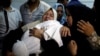 A relative mourns as she carries the body of 8-month-old Palestinian infant Laila al-Ghandour, who died after inhaling tear gas during a protest against the U.S. embassy move to Jerusalem, at the Israel-Gaza border, during her funeral in Gaza City, May 15, 2018.