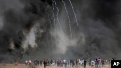Des Palestiniens manifestent devant des pneus brûlés dans l'est de Khan Younis, Gaza, 6 avril 2018.