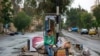 A Syrian boy waits his family to loads their belongings onto a bus in the town of Palmyra in the central Homs province, Syria, April 14, 2016.
