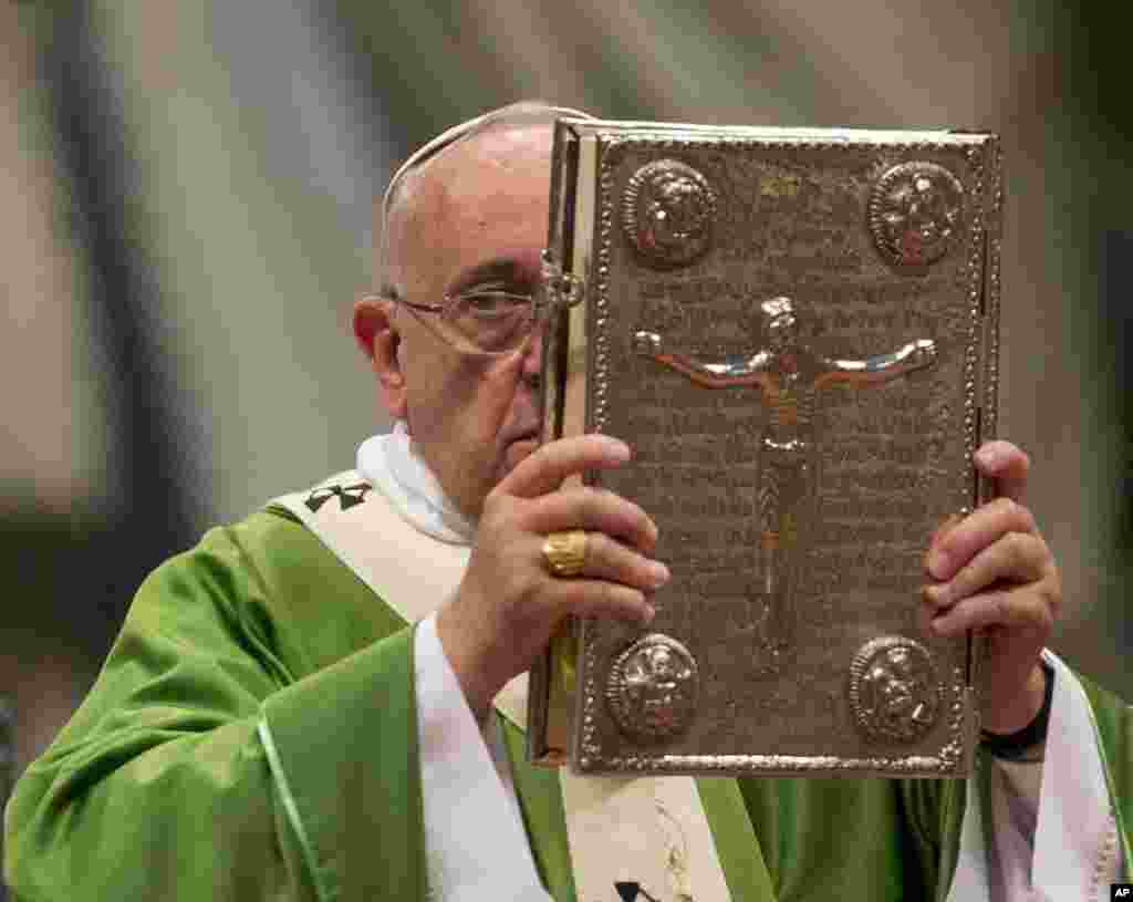 Le pape François hisse l’ Evangile lors d’une messe en la basilique Saint-Pierre au Vatican, le 5 octobre 2014, pour ouvrir le Synode extraordinaire sur la famille. (AP Photo / Alessandra Tarantino)