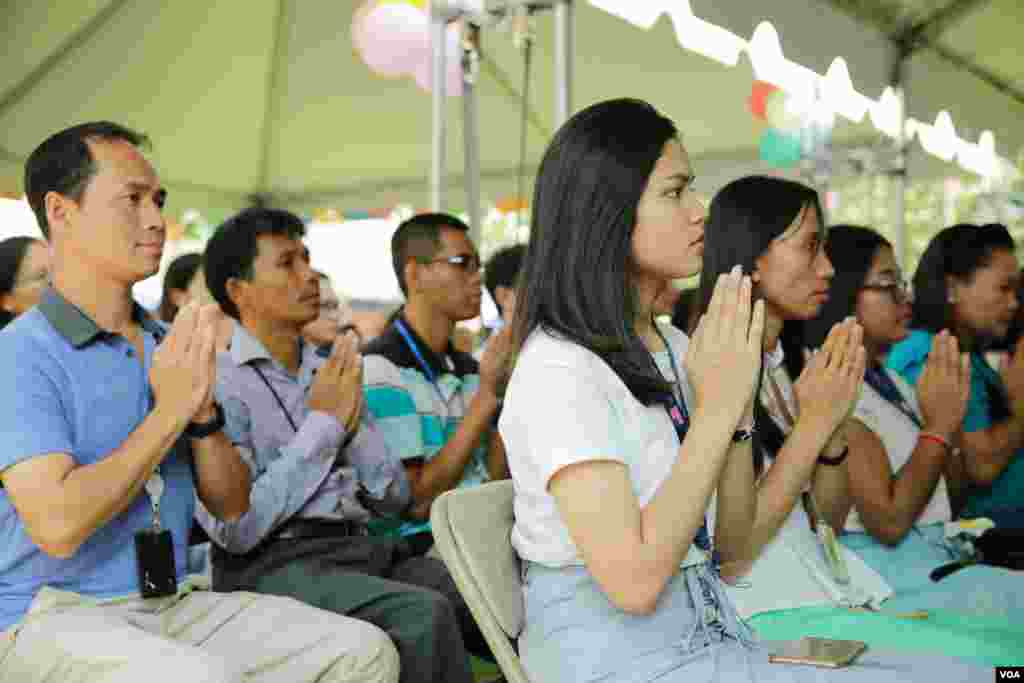 បុគ្គលិកស្ថានទូតអាមេរិកប្រចាំកម្ពុជា កំពុងអង្គុយសំពះសូត្រមន្ត ក្នុងការប្រារព្ធពិធីបុណ្យចូលឆ្នាំថ្មីប្រពៃណីជាតិខ្មែរ នៅក្នុងបរិវេណស្ថានទូតអាមេរិកប្រចាំកម្ពុជា នាថ្ងៃទី៦ ខែមេសា ឆ្នាំ២០១៨។(ទុំ ម្លិះ/VOA)