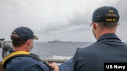 美國海軍照片顯示兩名軍官2021年4月4日在驅逐艦“馬斯廷號”上近距離觀察中國"遼寧號"航空母艦（美國海軍）