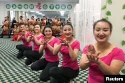 中國政府2019年1月5日組織外國記者和政府官員參觀新疆和田職業教育訓練中心時當地居民為他們表演。