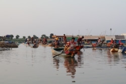 ប្រជាពលរដ្ឋរស់នៅតំបន់ឆ្នុកទ្រូទន្លេសាប ធ្វើដំណើរតាមទូកម៉ាស៊ីន ក្នុងស្រុកបរិបូរណ៍ ខេត្តកំពង់ឆ្នាំង កាលពីថ្ងៃទី ១២ ខែមីនា ឆ្នាំ២០២០។ (ស៊ុន ណារិន/វីអូអេ)