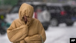 一位婦女在暴風雪中的北京街道上行走。