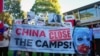 Uyghur and other demonstrators hold a banner and placards as they await the arrival of Chinese Premier Li Qiang in Adelaide, Australia, on June 16, 2024. Human rights groups said on June 20 that the U.N. must act on a two-year-old report of rights violations against the Uyghurs.