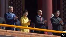 ប្រធានាធិបតី​ចិន​លោក Xi Jinping (ខាងស្តាំ) ទះដៃ​ជាមួយ​ប្រធានាធិបតី​កាហ្សាស្តង់ Nursultan Nazarbayev (ខាងឆ្វេង) ប្រធានាធិបតីកូរ៉េខាងត្បូងលោកស្រី Park Geun-hye និងប្រធានាធិបតី​រុស្ស៊ី​លោក​ Vladmir Putin នៅ​អំឡុងពេល​ដង្ហែ​ក្បួនយោធា​នៅ​ក្រុង​ប៉េកាំង​ នា​ថ្ងៃ​ទី០៣ ខែកញ្ញា ឆ្នាំ២០១៥។