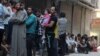 People line up for bread in the rebel-held al-Shaar neighborhood of Aleppo, Syria, July 14, 2016. 