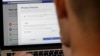 FILE - A man poses a photo in front of a computer showing Facebook ad preference pages, in San Francisco, California, March 26, 2018.