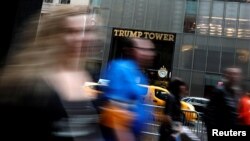 FILE - Pedestrians are seen in a slow shutter speed photograph as they pass Trump Tower on 5th Avenue in New York City, April 26, 2017.