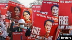 Demonstrators hold placards with the image of Aung San Suu Kyi during a protest against the military coup, in Naypyitaw, Myanmar, Feb. 17, 2021.