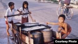 កុមារ​កម្ពុជា​ជញ្ជូន​ទឹក​ដើម្បី​យក​ទៅ​ប្រើប្រាស់​។ ​រូបភាព​ថតនៅភ្នំពេញ​ ​ក្នុង​ឆ្នាំ១៩៨០។ ​(រូប​ផ្តល់​ឱ្យ​ដោយលោក​​ John Burgess)