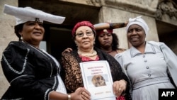 Esther Utjiua Muinjangue, à gauche, présidente de la Fondation du génocide d'Ovaherero en Namibie, et les membres de la délégation namibienne posent devant le ministère de la Justice lors d'une réception en marge d'une restitution officielle des restes de tribus Herero et Nama à Berlin le 27 août 2018.