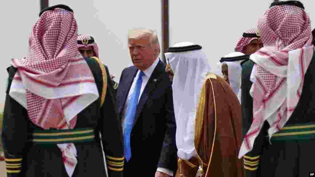 Le président Donald Trump, au centre, à gauche, marche aux côtés du roi saoudien Salman à l’aéroport international roi Khalid, Ryad 20 mai 2017.