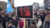 People stand in silence to commemorate the 15 victims of a railway roof collapse that occurred one month ago, in Novi Sad, Serbia, Dec. 1, 2024.